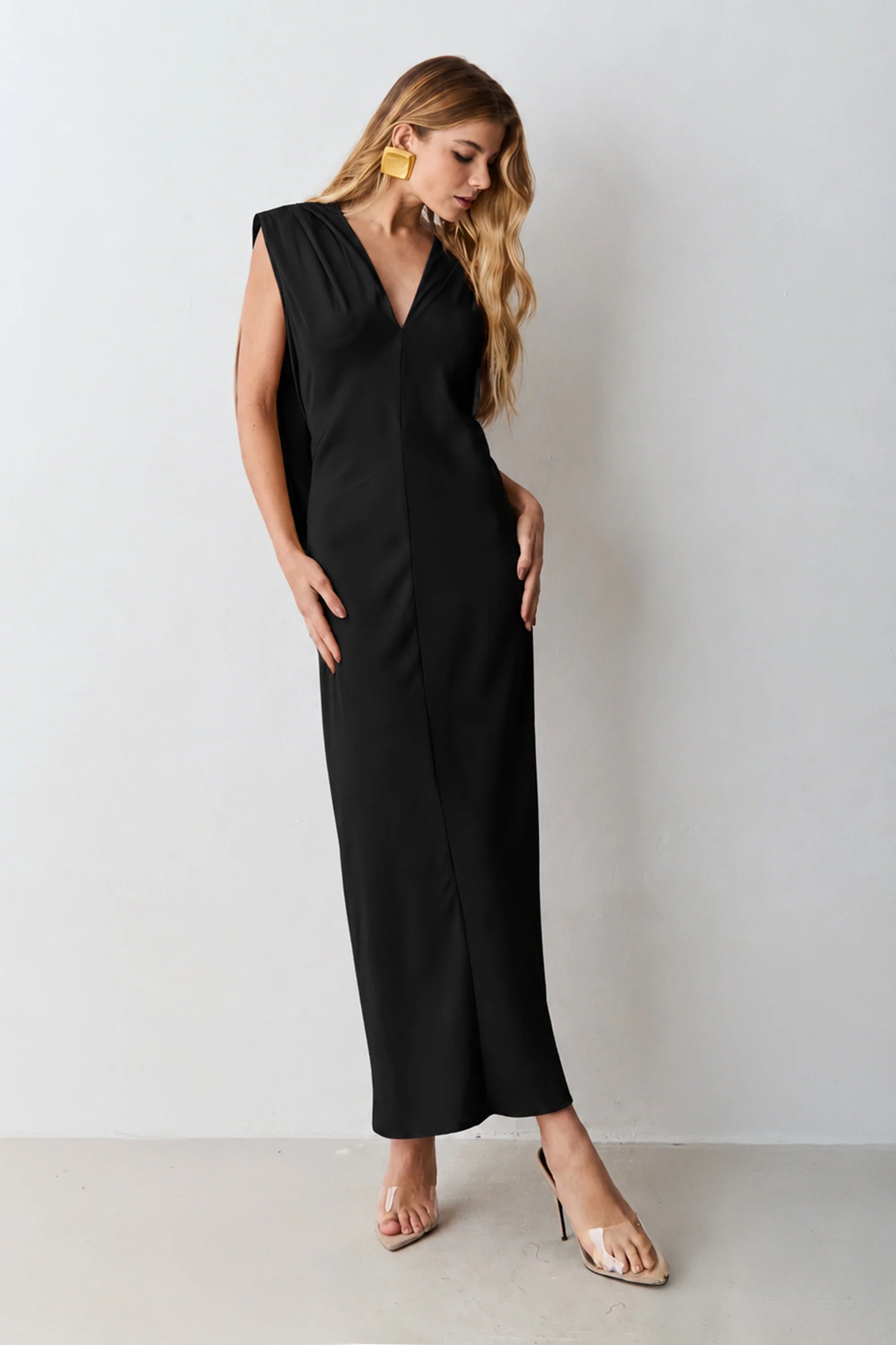 Black V-neck midi dress with shoulder pads and back detailing.