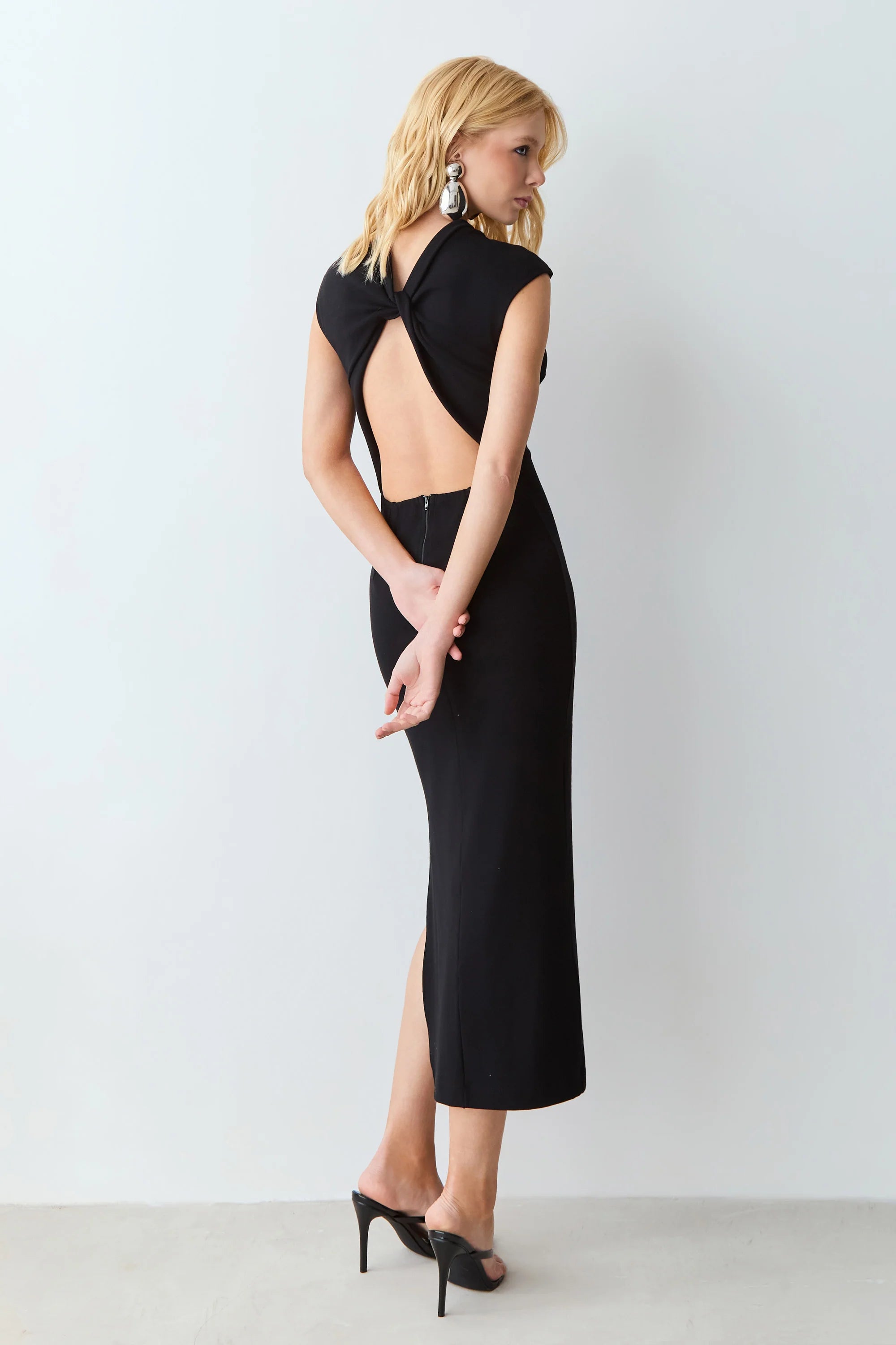 Black midi dress with a medium neckline and a twist-back cutout.