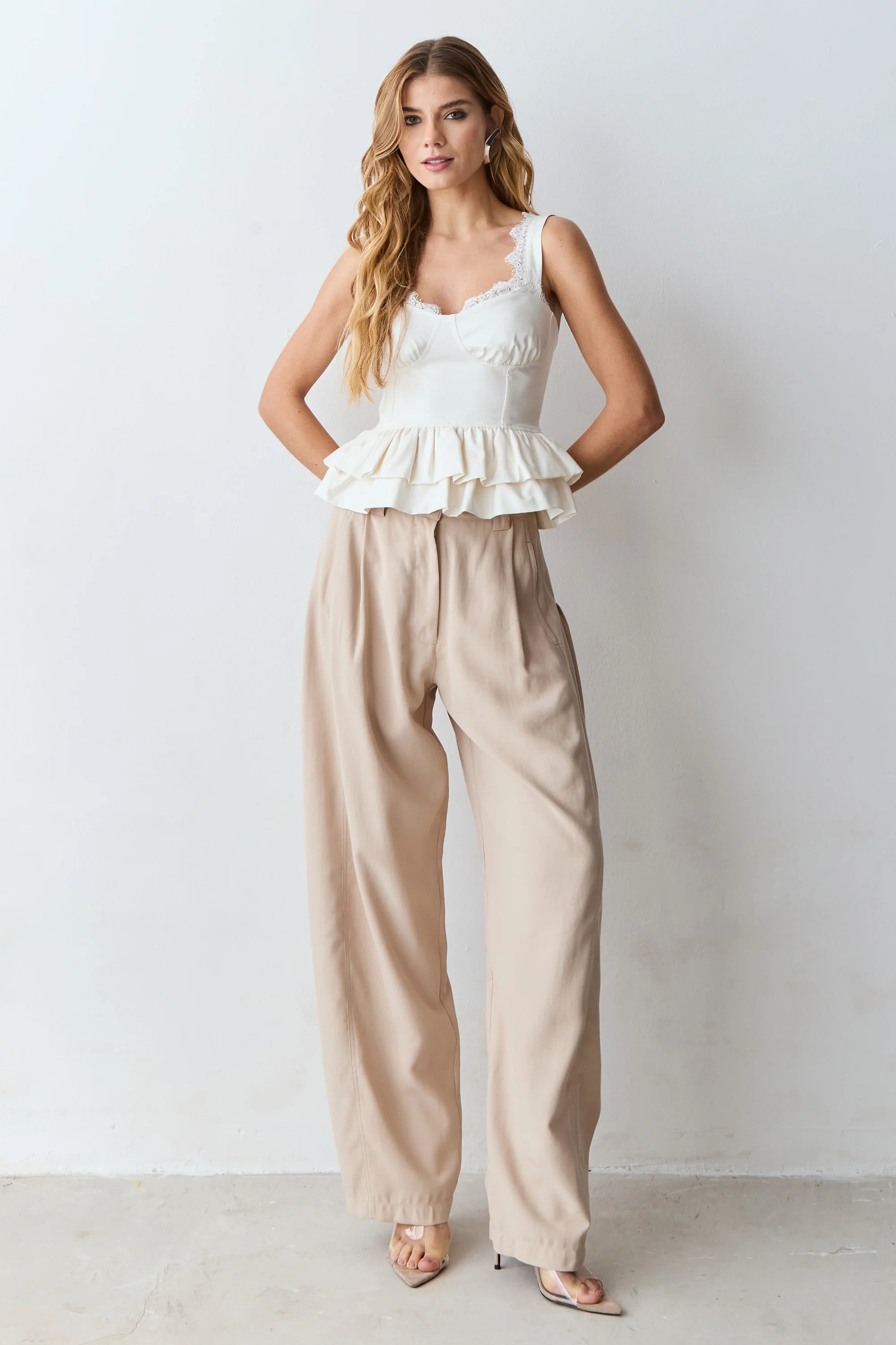 White lace tank top with structured hem, featuring a specific neckline and straps.