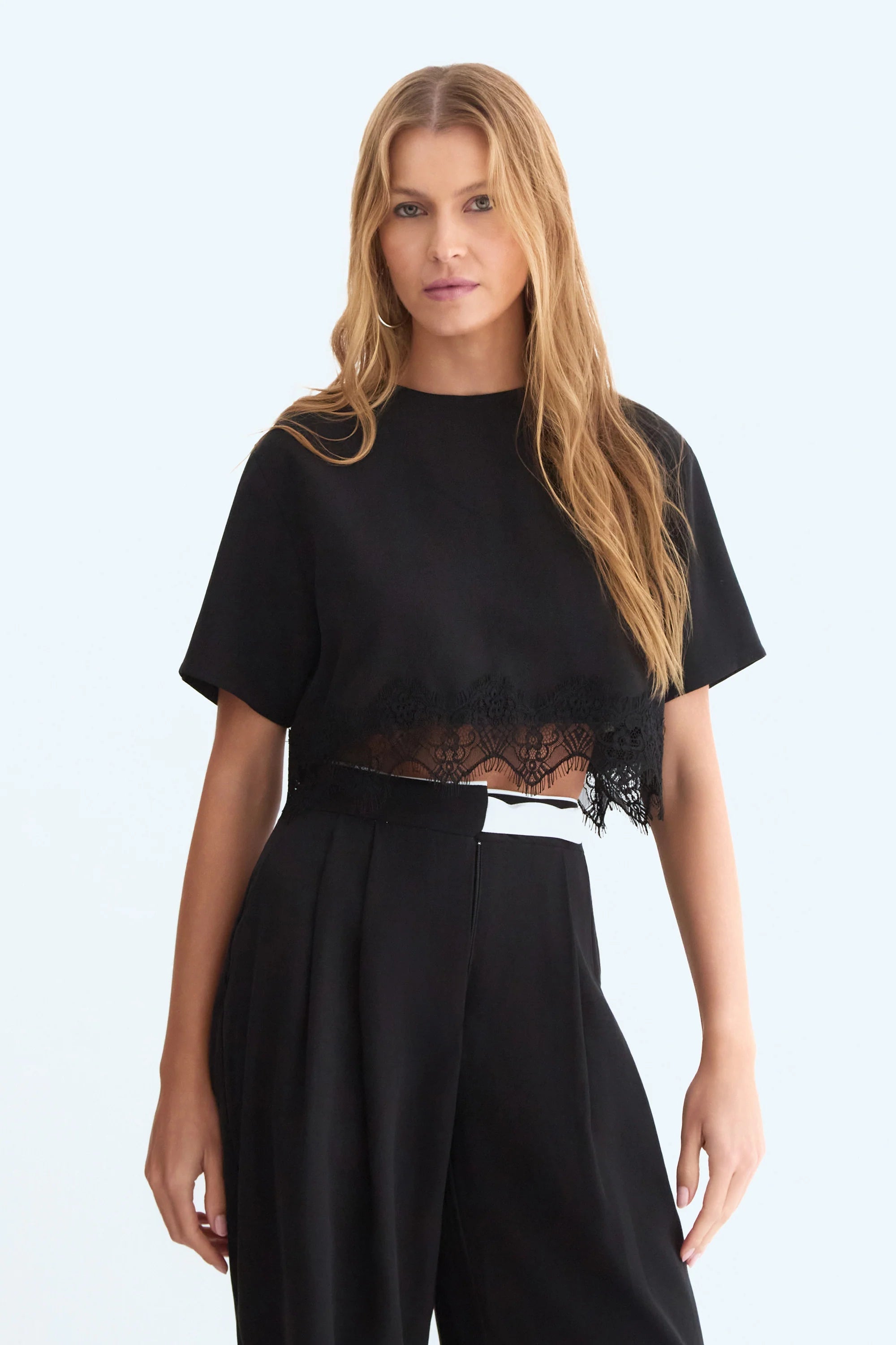 Black fluid short-sleeve blouse with lace detail at the hem